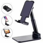 Adjustable Desk Phone Holder in black plastic with a broad base, angled support arm, and padded phone cradle
